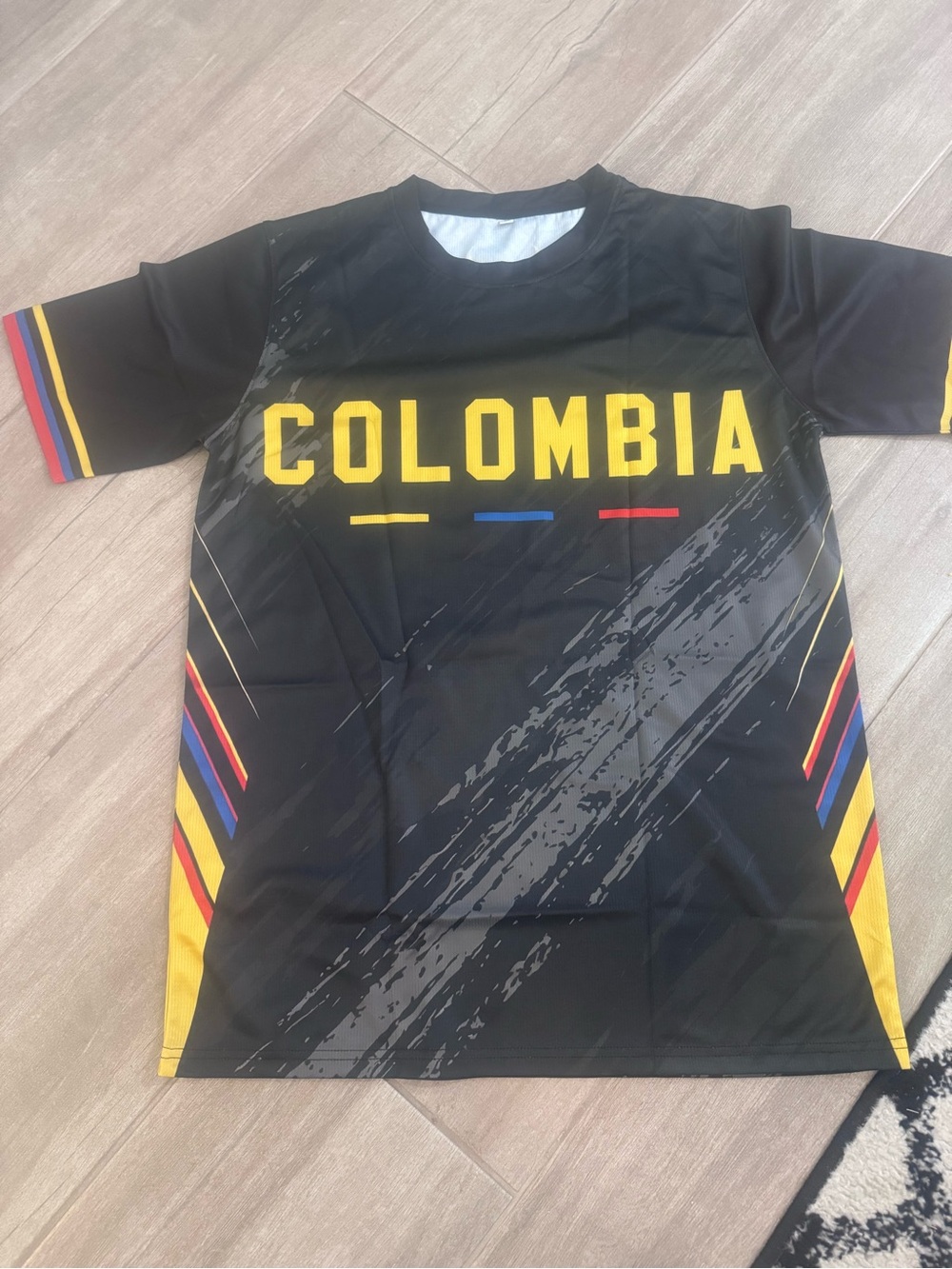 Never worn Black Colombia Tee with Yellow, Blue & Red Accents